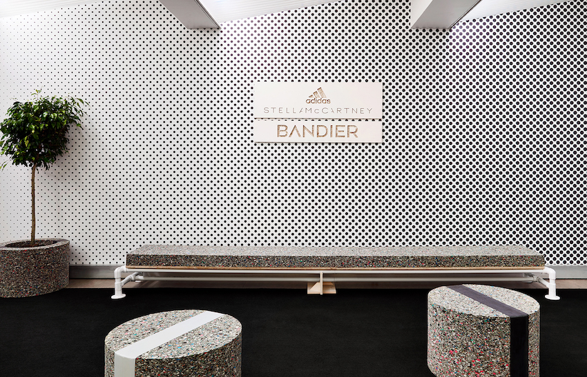 A foam bench under a black and white halftone printed wall with the Stella McCartney Bandier logo lockup.