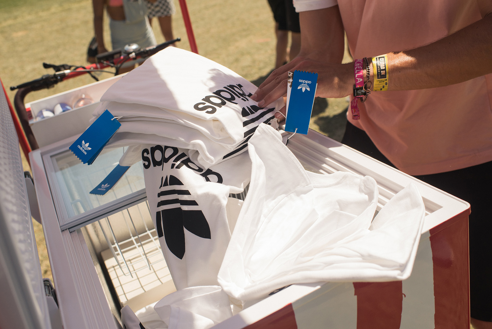 Folded adidas shirts being pulled out of a red ice cream cart.