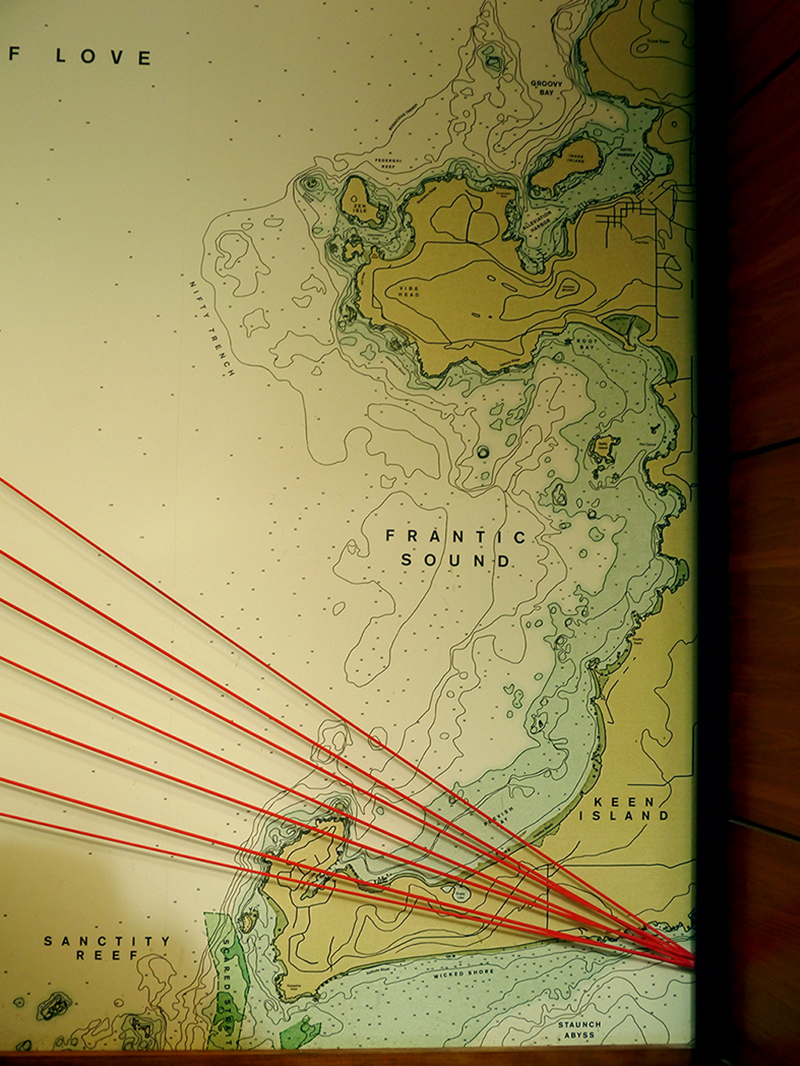 One of the wall maps features locations around Frantic Sound, including Nifty Trench, Keen Island, Sanctity Reef, and Wicked Shore. Seven orange cords fan over top, angled so they meet at a point on the right side.