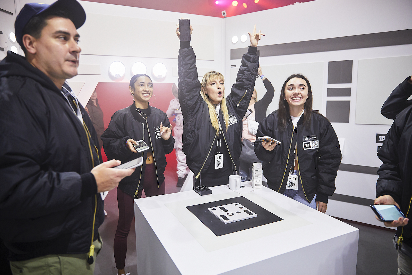 A group celebrates, with smiles and arms raised, as they solve the puzzle.