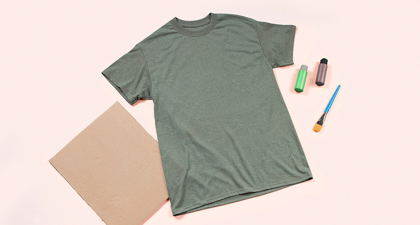 Step 1: Gather supplies: a shirt, a piece of cardboard, green and brown fabric paint, a one-inch wide flat paintbrush.