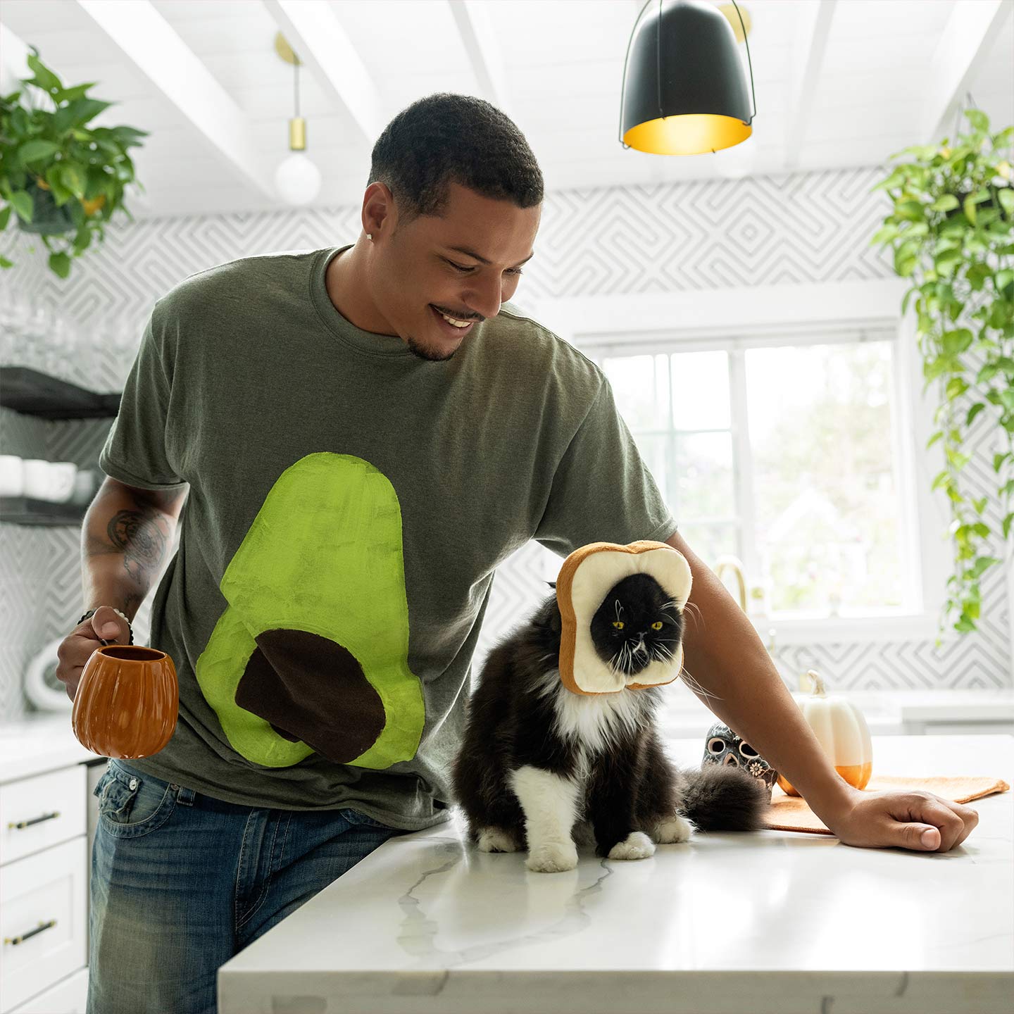 Man wearing avocado tee shirt with cat dressed as toast.